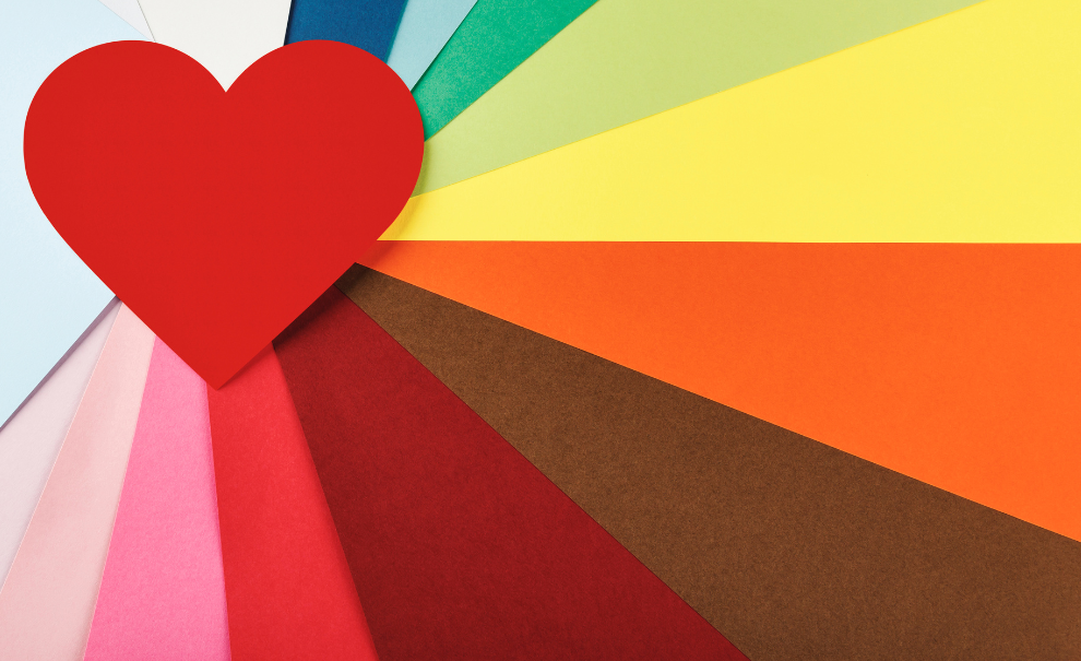 A red heart to the top left side of the image with rays of rainbow colors coming out from behind the heart.