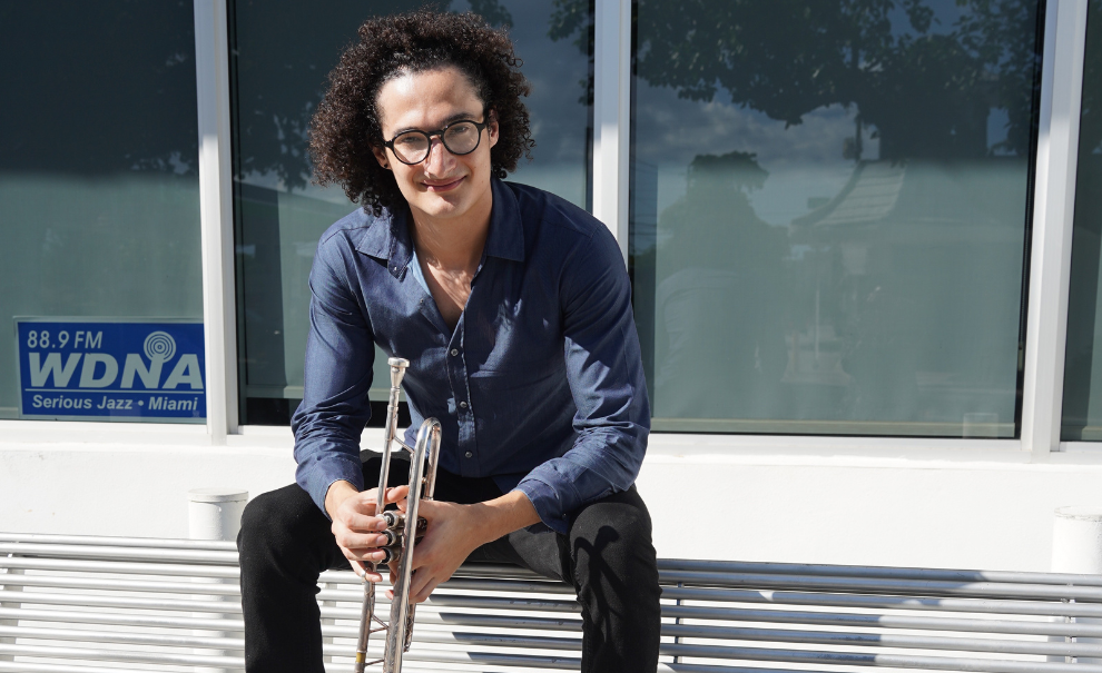 image of Noam on a bench holding a trumpet