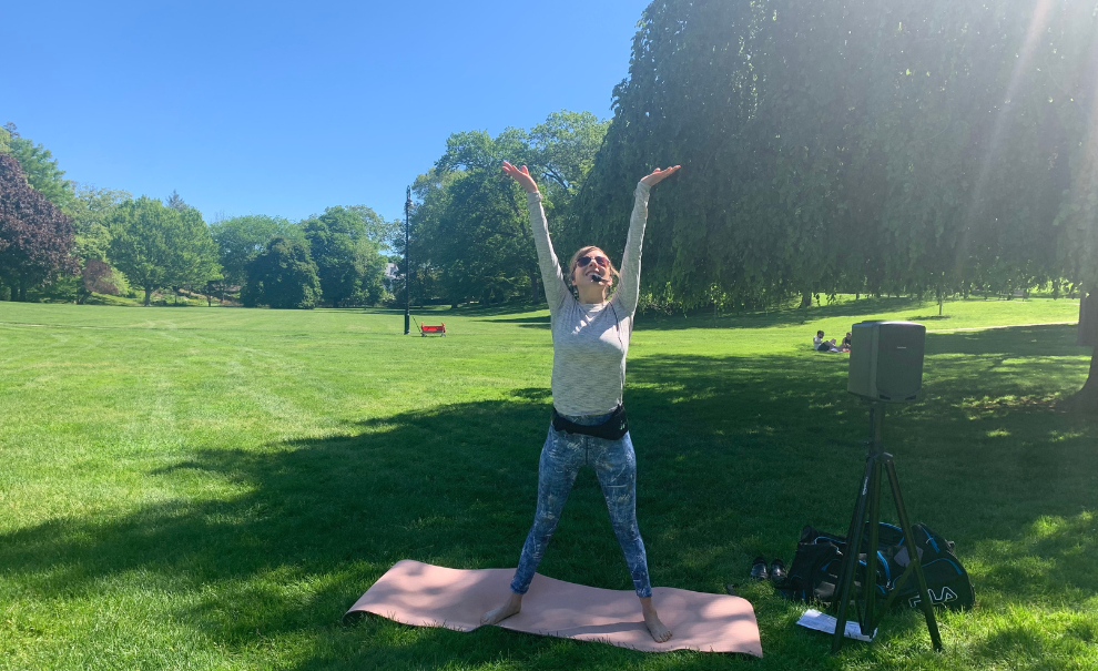 woman stretching outside in the park with microphone and speakers