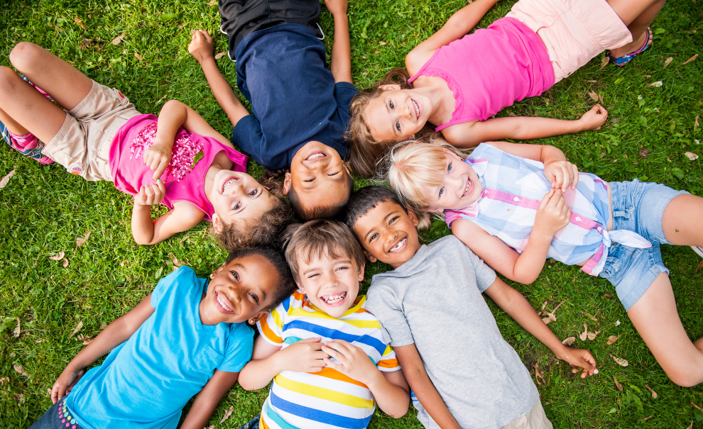 kids laying down on grass in circle