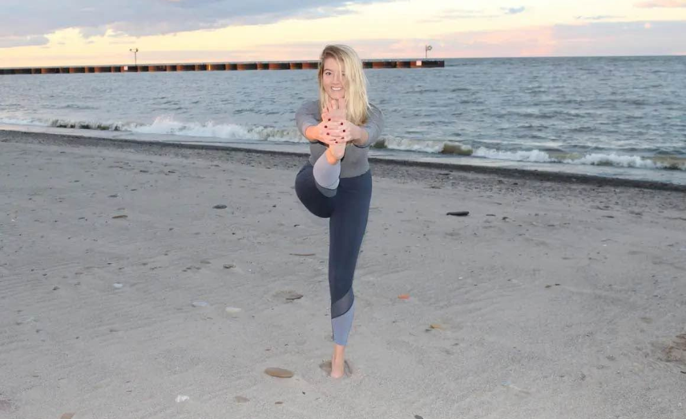 female doing a yoga pose on the beach
