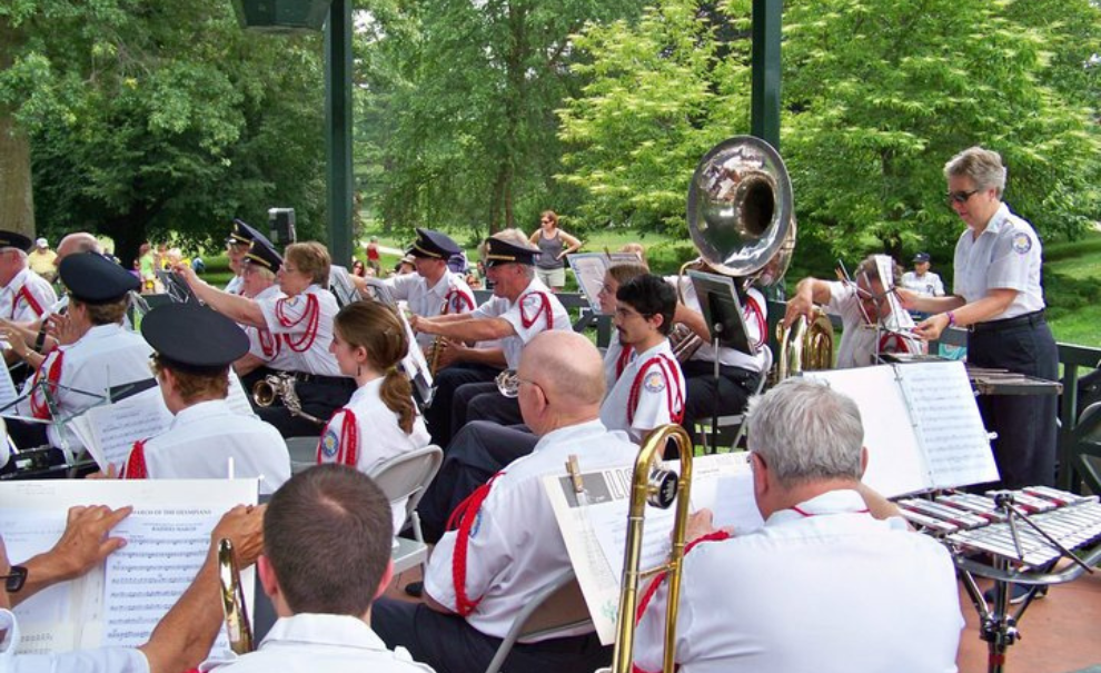 a group of adults playing various instruments in a bandstand