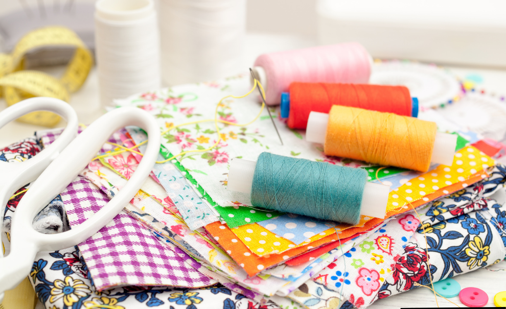spools of colorful thread, printed fabrics, and white shears