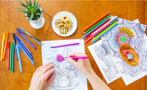 hands coloring on worksheet with a plate of cookies
