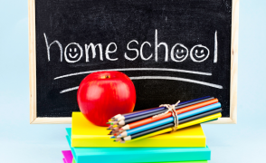 chalkboard with the words "homeschool" a pile of books and an apple