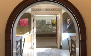 arched entryway into hoxie gallery with portrait images on the wall