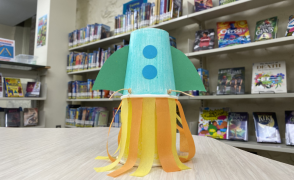 paper cup rocket pictured in front of library shelves