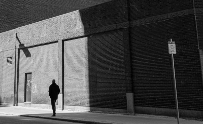 image of silhouette on street corner with building in the background