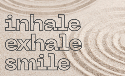 A zen garden of sand with concentric rings and the words Inhale, Exhale, Smile.