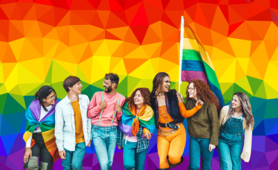 Group of teens with pride flags in front of a geometric patterned rainbow colored background. 