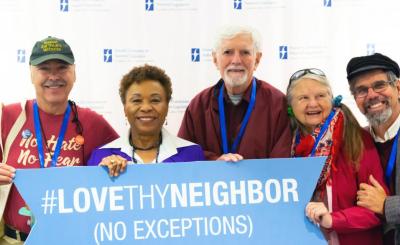 lovethyneighbor sign held by smiling people