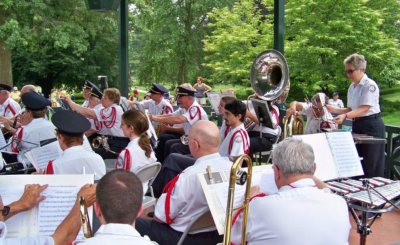 a group of adults playing various instruments in a bandstand