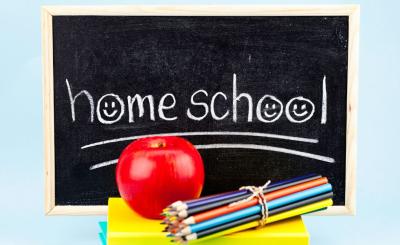 Image of chalkboard that says "homeschool" next to a stack of books, color pencils, and an apple