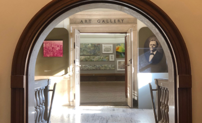 arched entryway into hoxie gallery with portrait images on the wall