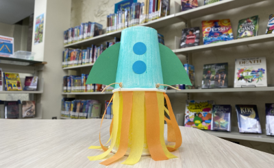 paper cup rocket pictured in front of library shelves