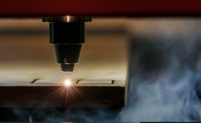 A laser cutter engraving a piece of wood